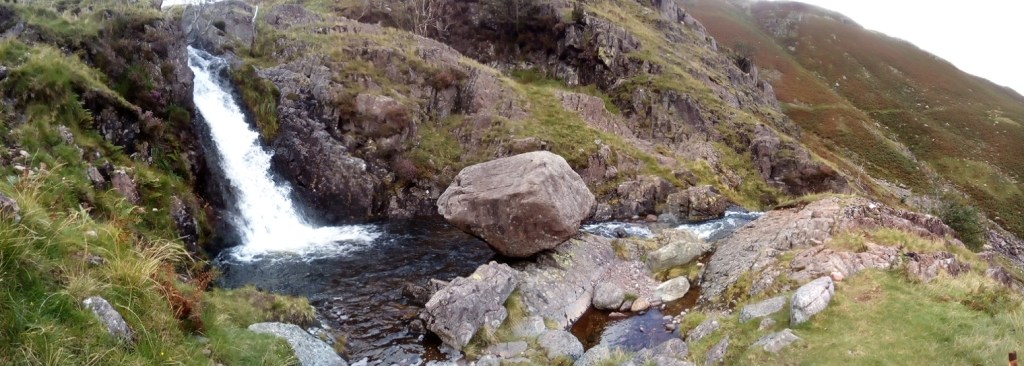 A photo of a boulder balanced over a stream in the Lake District.
